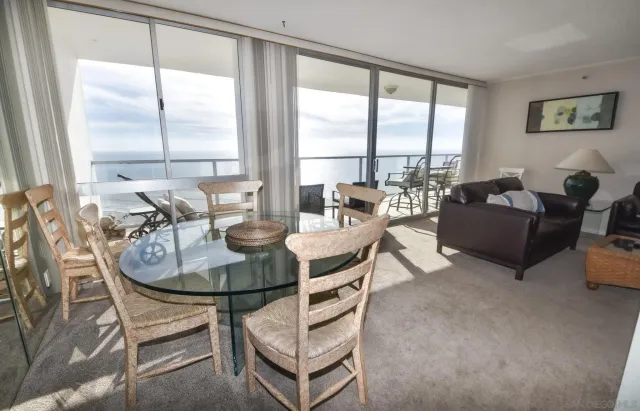 a living room with furniture a large window and a chandelier