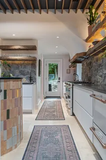 an empty room with wooden floor cabinet and windows