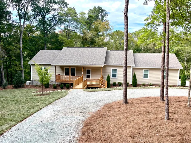 a view of a house with a yard and sitting area