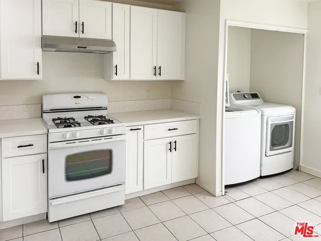 a kitchen with a sink a stove and cabinets