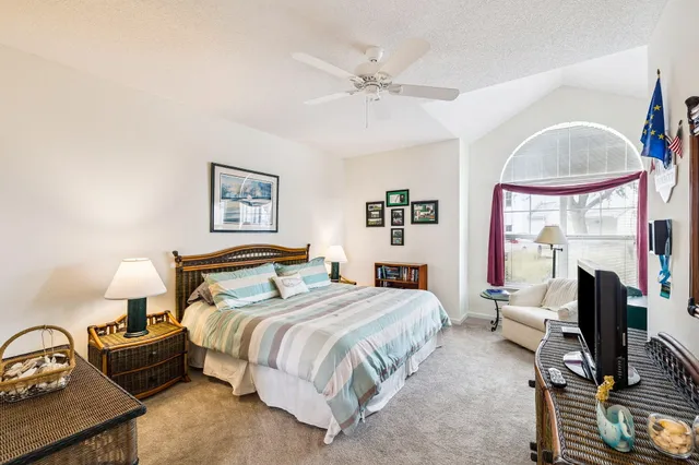 a bedroom with a bed a mirror and a large window