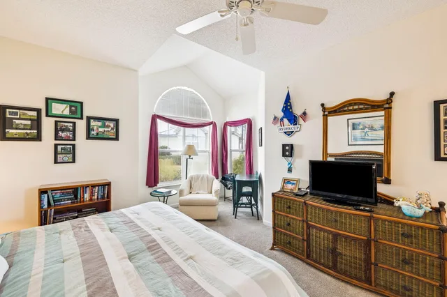 a bedroom with a bed a flat screen tv and a dresser