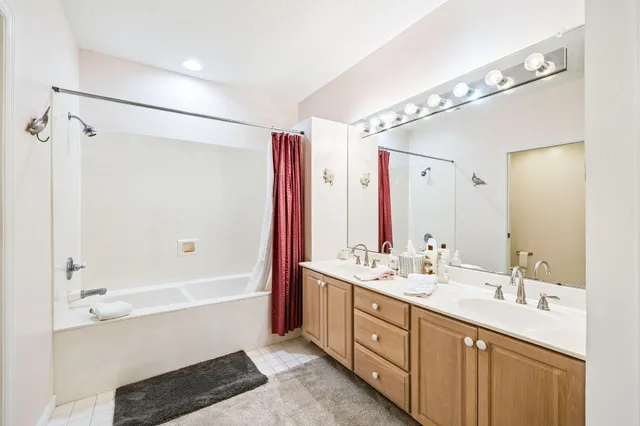a bathroom with a double vanity sink mirror double and shower