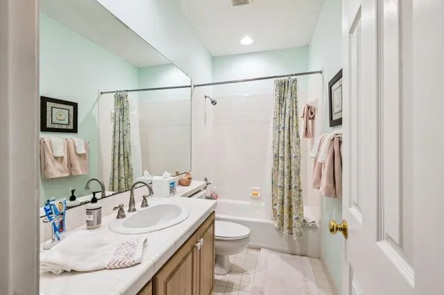 a bathroom with a granite countertop sink a toilet and shower
