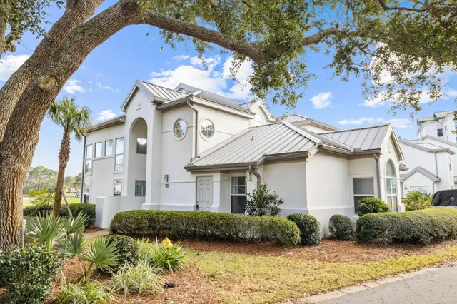 a view of a white house with a yard and plants