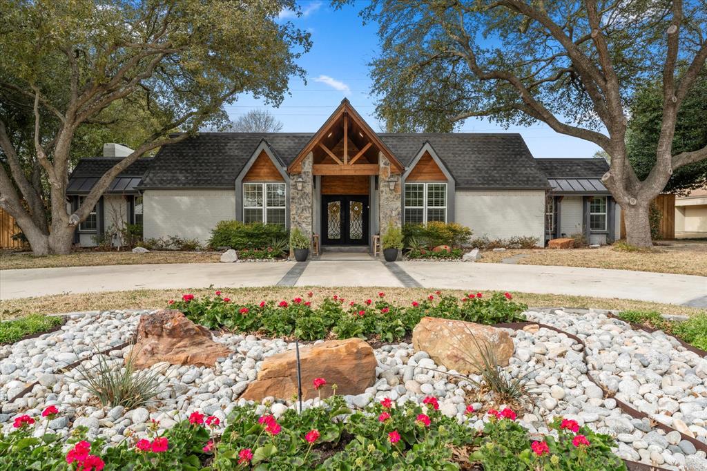 5505 Northaven Road Dallas, TX 75229 - Photo 11 of 40 View of front facade featuring roof with shingles, a chimney, french doors, stone siding, and brick siding