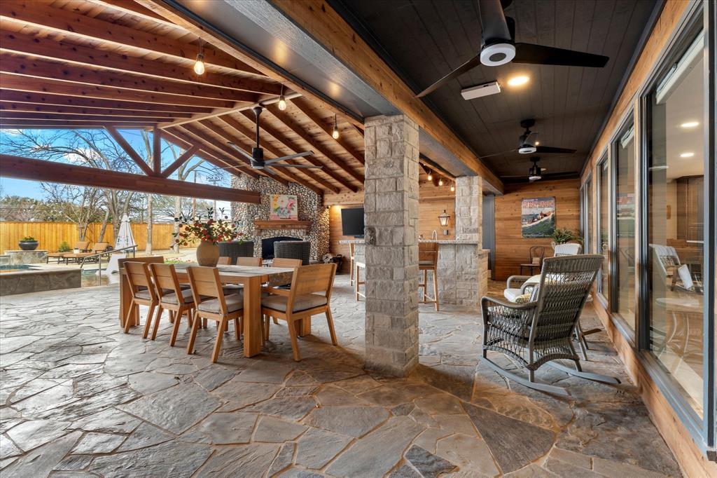 5505 Northaven Road Dallas, TX 75229 - Photo 13 of 40 View of patio featuring outdoor dry bar, ceiling fan, fence, an outdoor stone fireplace, and outdoor dining area