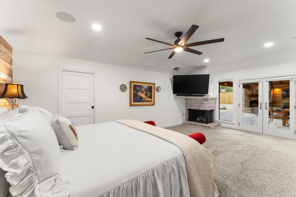 5505 Northaven Road Dallas, TX 75229 - Photo 26 of 40 Bedroom featuring carpet floors, ornamental molding, access to exterior, french doors, and a brick fireplace