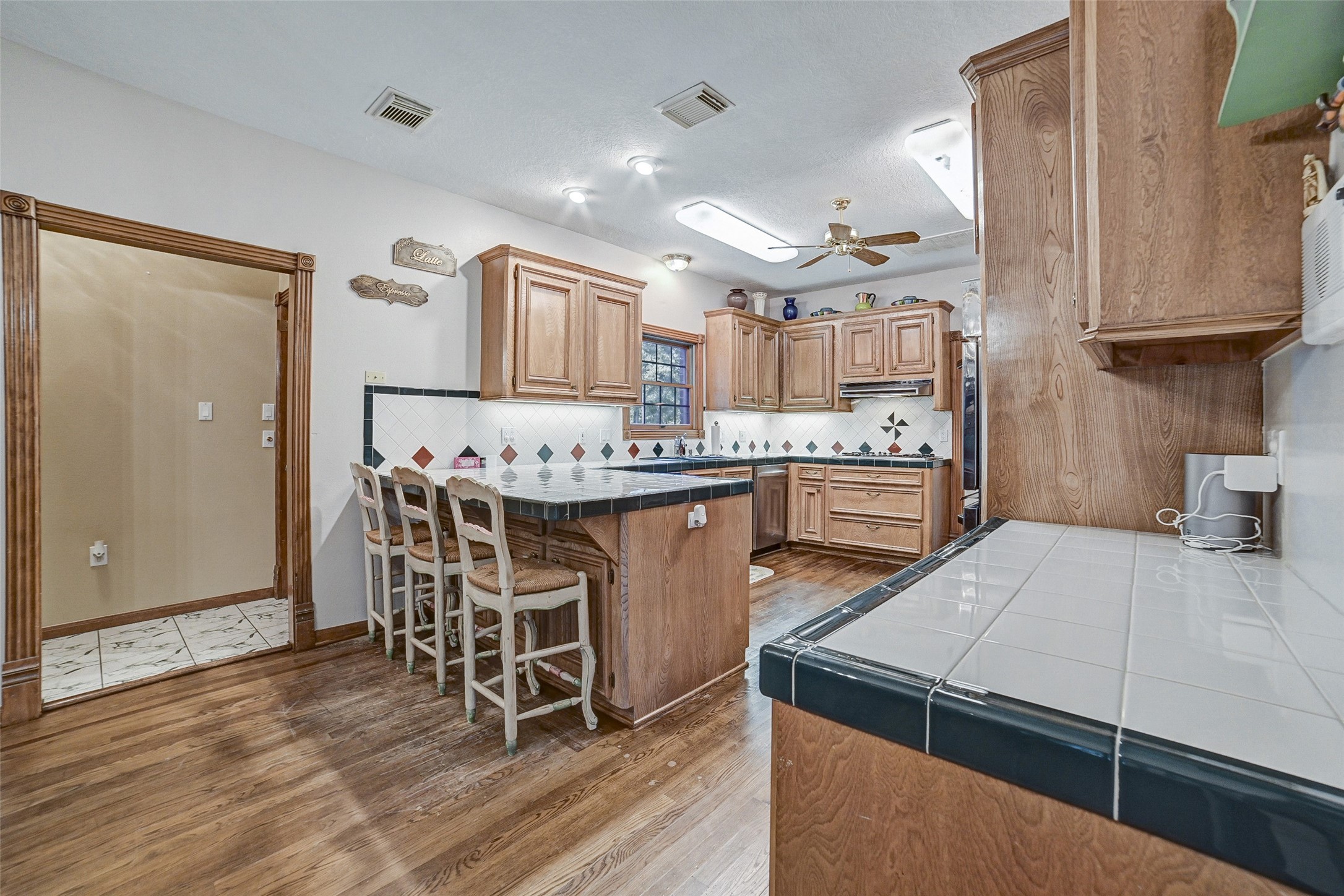 29803 Huffman Cleveland Road Huffman, TX 77336 - Photo 14 of 49 a kitchen with a table chairs a stove a microwave and cabinets