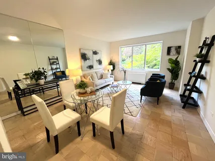 a living room with furniture a large window and a dining table