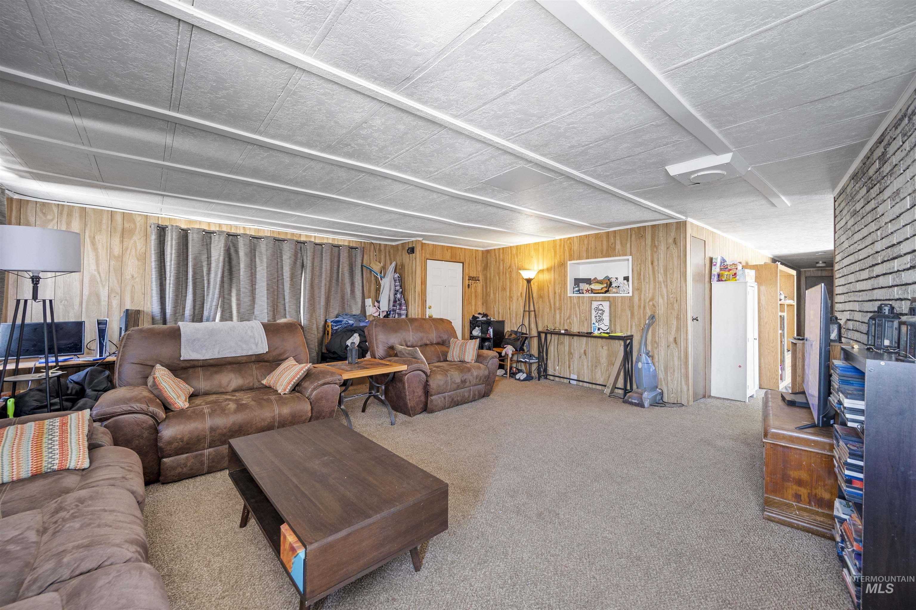 2382 East Syringa Street Eagle, ID 83616 - Photo 17 of 25 Living area featuring wooden walls and carpet flooring
