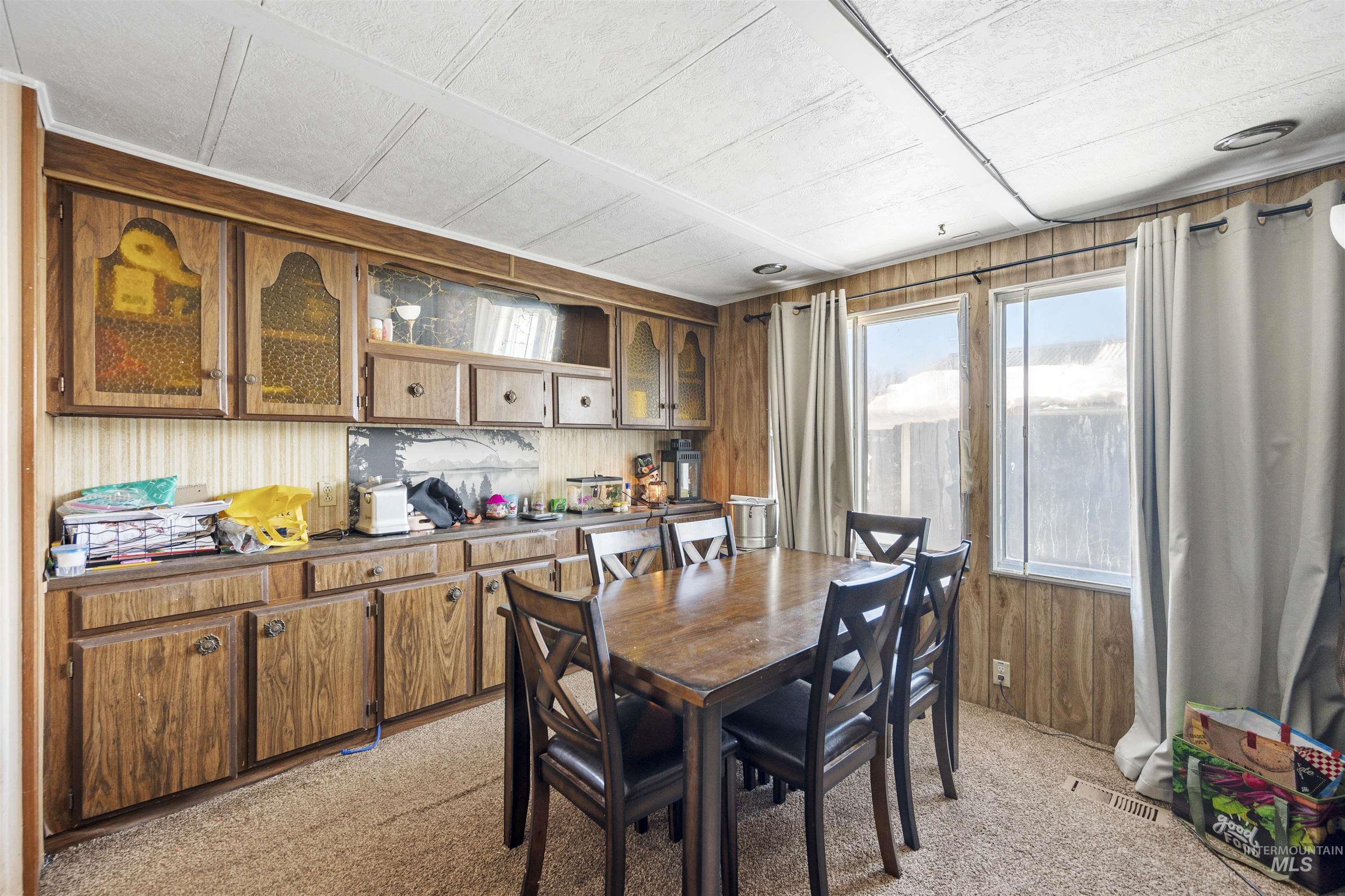 2382 East Syringa Street Eagle, ID 83616 - Photo 18 of 25 Dining area featuring light colored carpet and wood walls