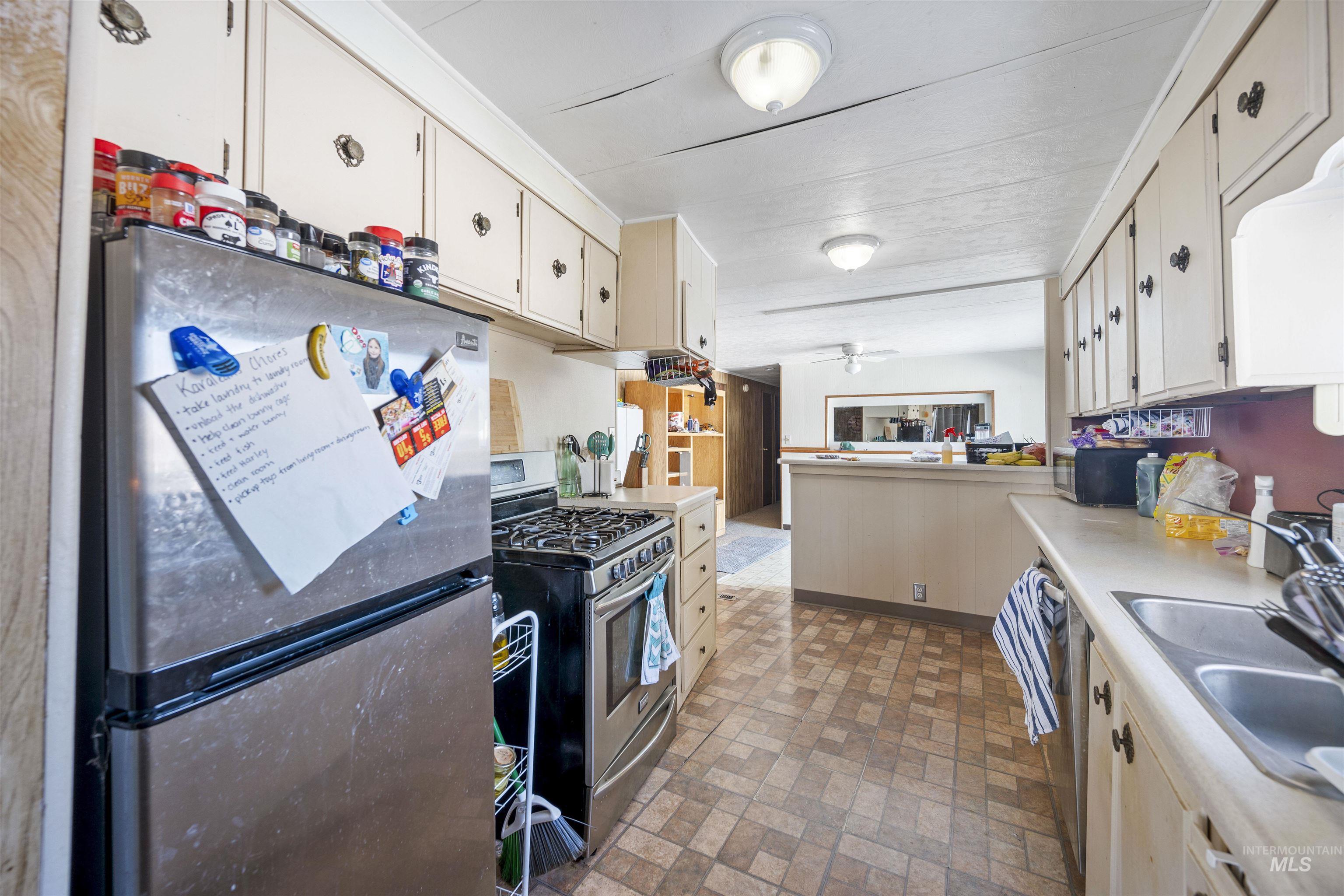 2382 East Syringa Street Eagle, ID 83616 - Photo 20 of 25 Kitchen with stainless steel appliances, brick patterned floors, light countertops, and a peninsula