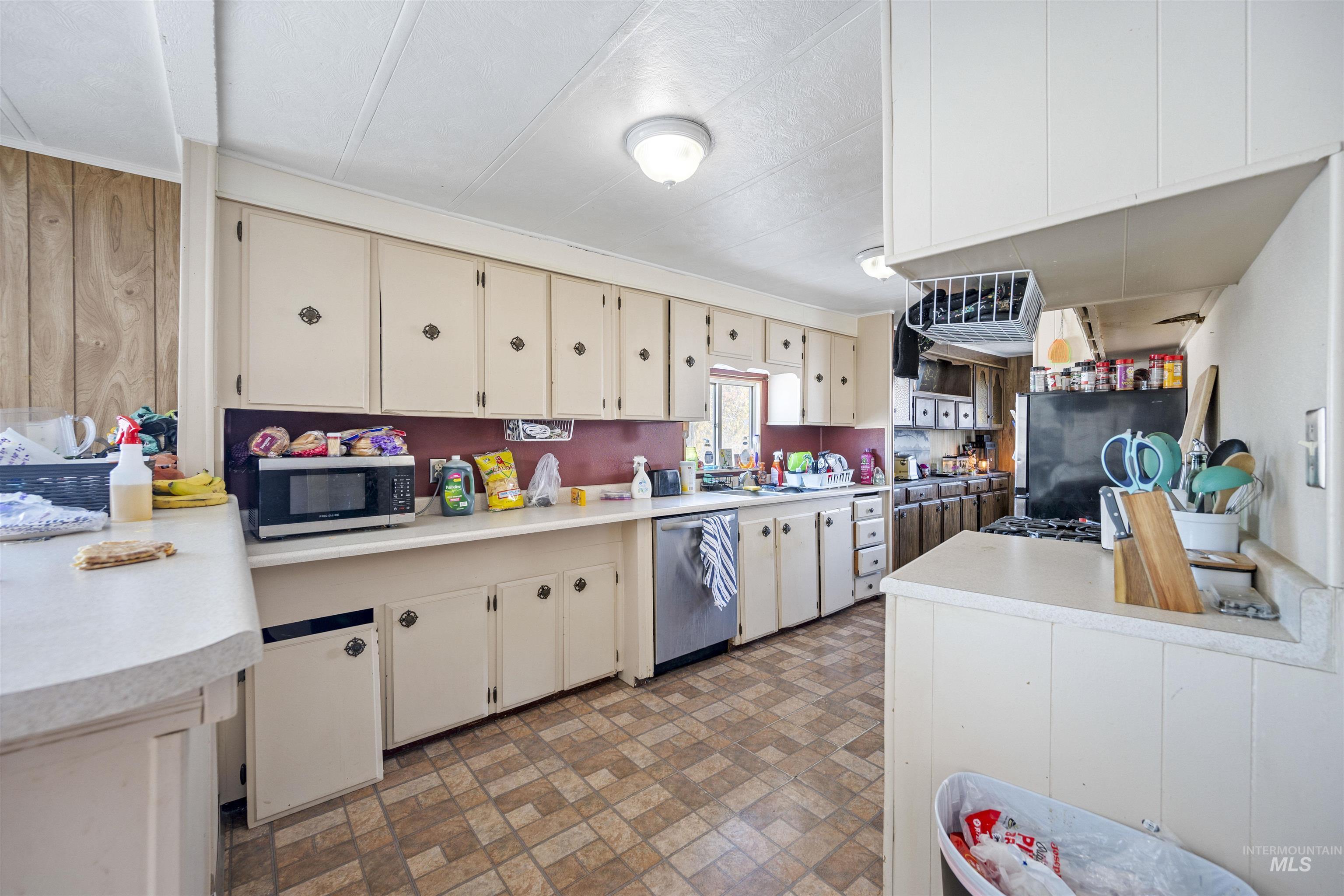 2382 East Syringa Street Eagle, ID 83616 - Photo 21 of 25 Kitchen with cream cabinets, brick patterned floors, light countertops, and stainless steel appliances