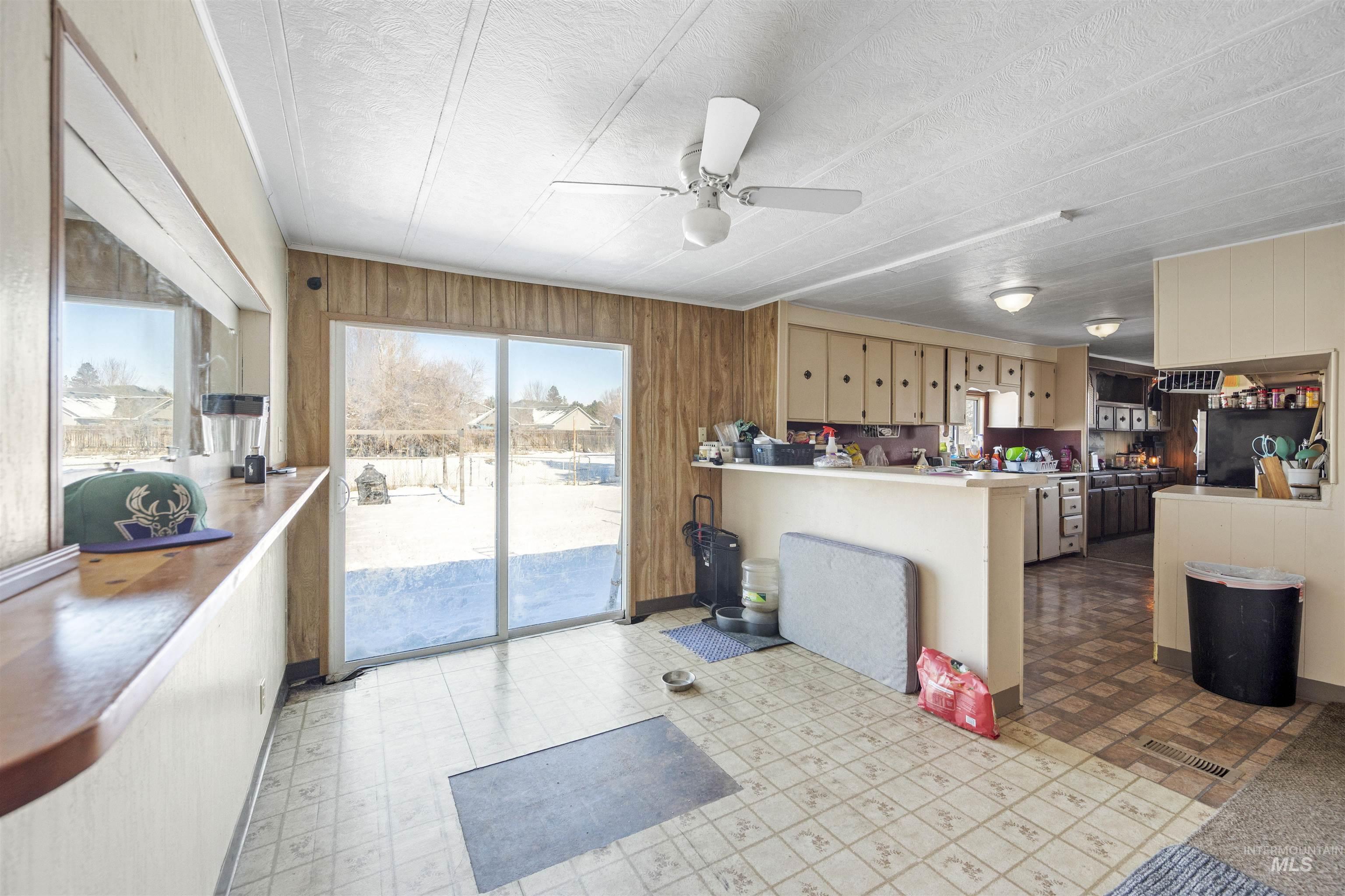 2382 East Syringa Street Eagle, ID 83616 - Photo 22 of 25 Kitchen featuring wood walls, light flooring, healthy amount of natural light, a peninsula, and a ceiling fan