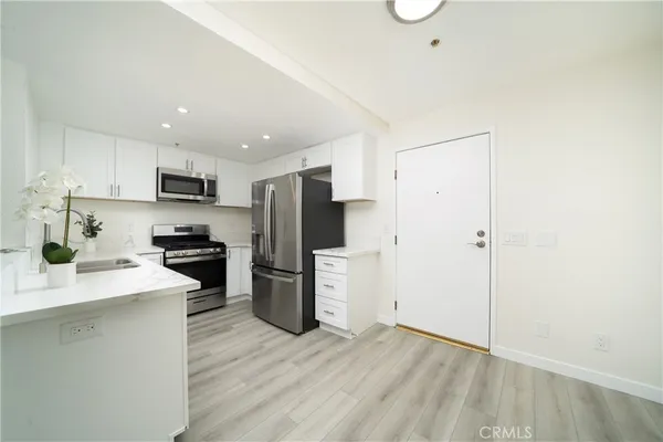 a kitchen with a refrigerator a stove top oven a sink and a counter top space