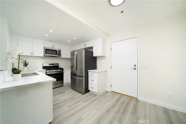 a kitchen with a refrigerator a stove top oven a sink and a counter top space