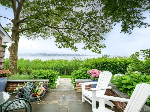 an outdoor sitting area with furniture and garden view
