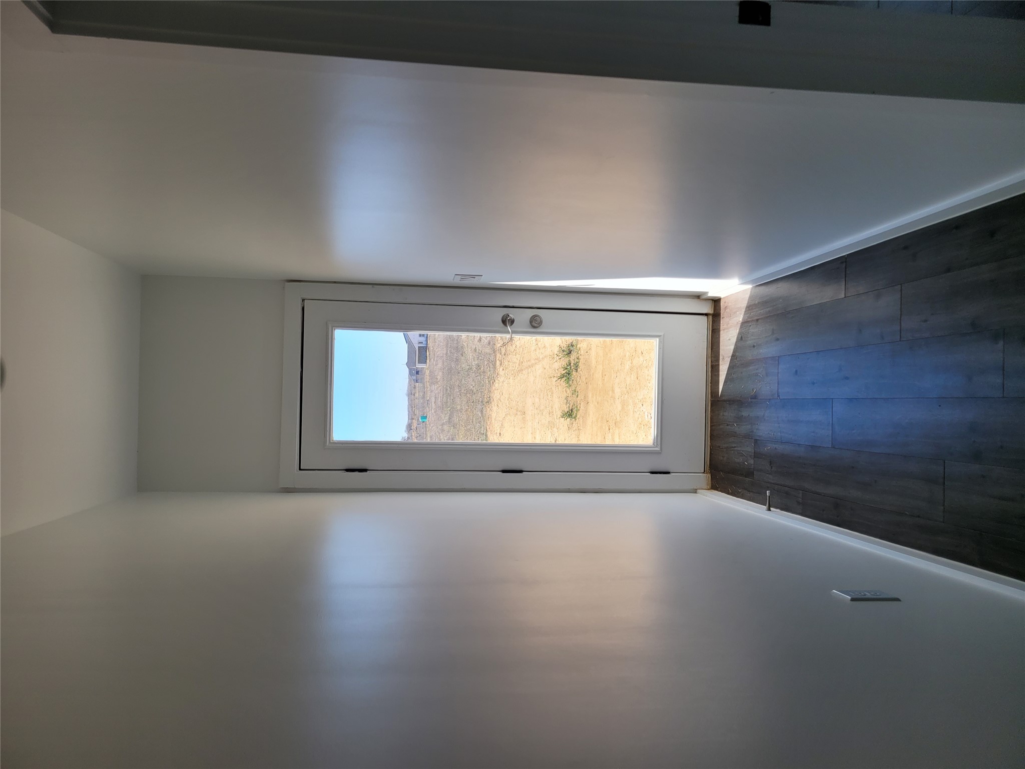 422 A Road Stockdale, TX 78160 - Photo 15 of 40 A glass-paneled door at the end of a hallway offers a glimpse of the undeveloped landscape outside.