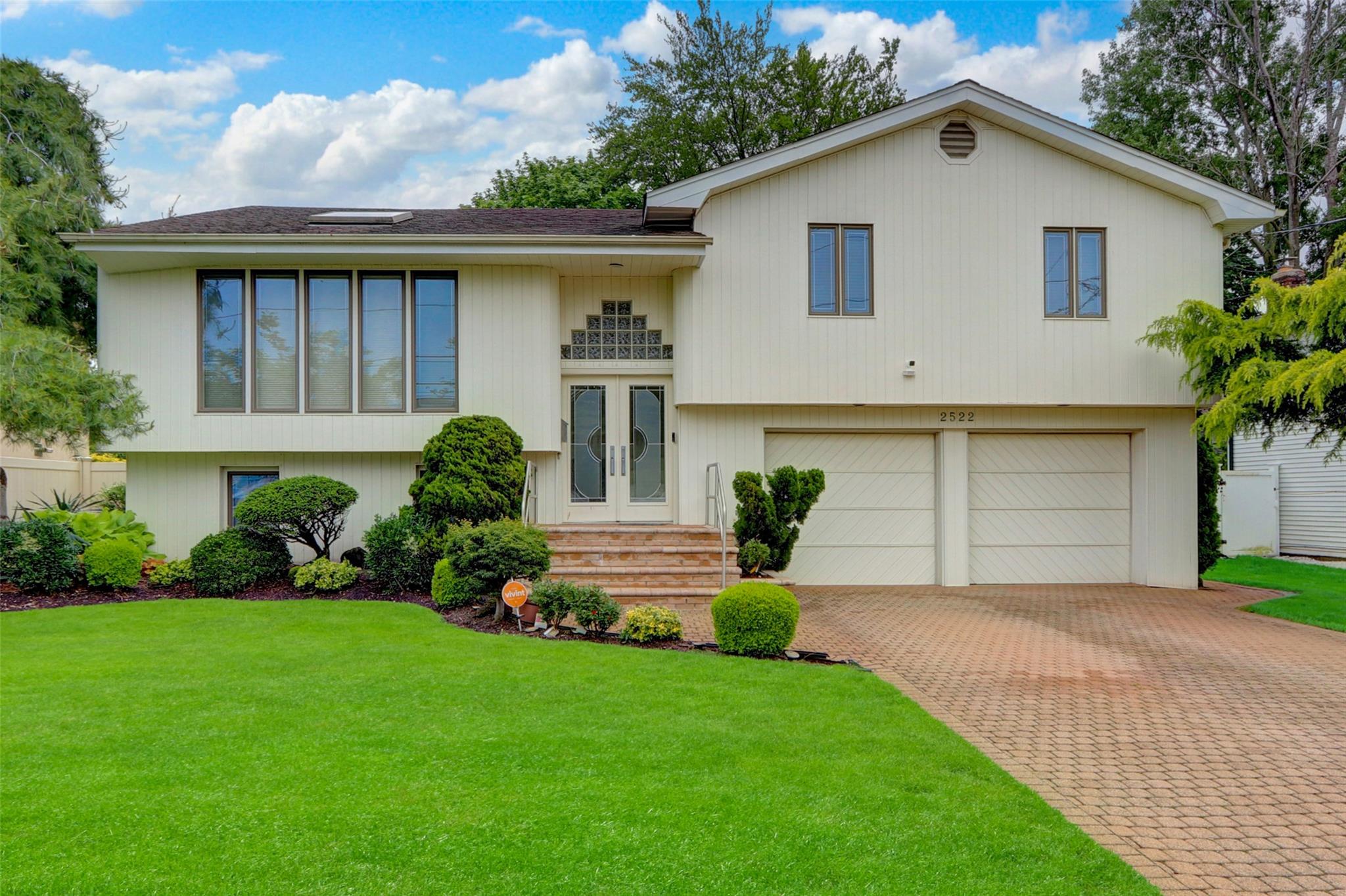 a front view of a house with a garden and plants