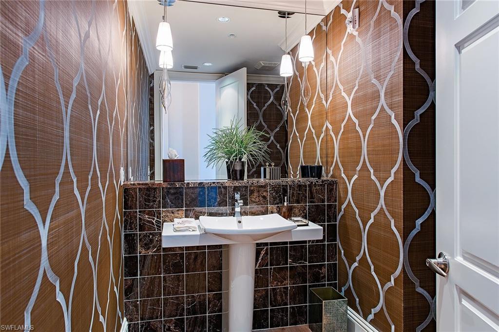 750 11th Street South, Unit C Naples, FL 34102 - Photo 11 of 25 a bathroom with a sink and mirror with shower