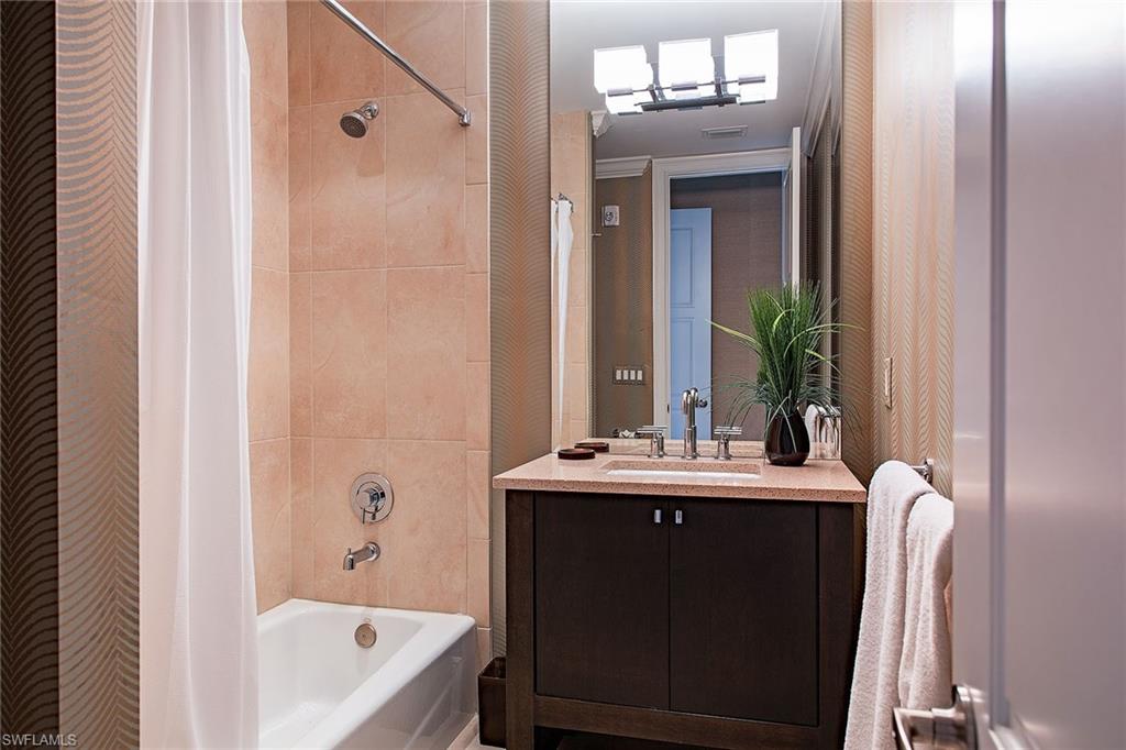 750 11th Street South, Unit C Naples, FL 34102 - Photo 19 of 25 a bathroom with a bathtub sink and mirror