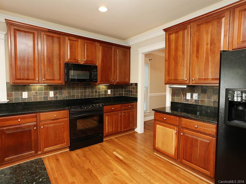 329 Third Baxter Street Fort Mill, SC 29708 - Photo 12 of 23 a kitchen with stainless steel appliances granite countertop wooden cabinets a stove top oven a sink and dishwasher