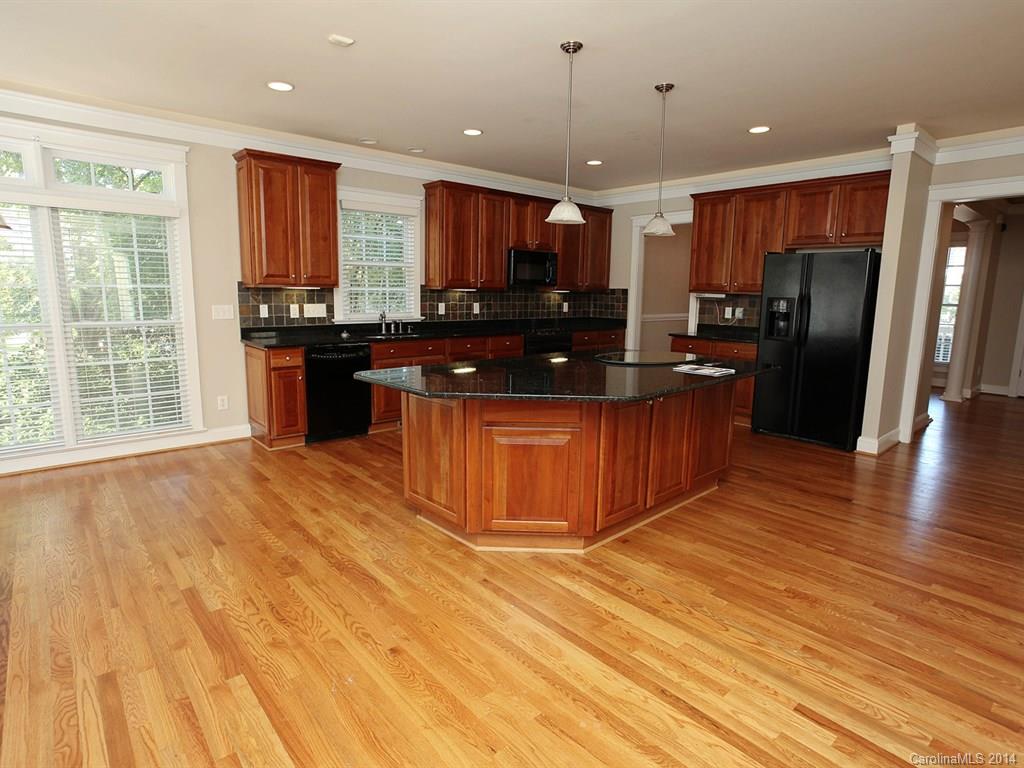 329 Third Baxter Street Fort Mill, SC 29708 - Photo 10 of 23 a kitchen with stainless steel appliances granite countertop a refrigerator a sink dishwasher a oven and a dining table with wooden floor