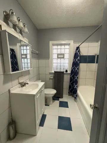 a bathroom with a sink a toilet a mirror a vanity and window