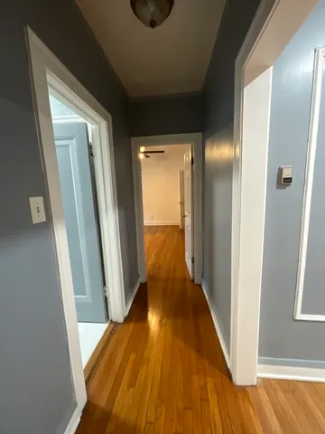 a view of a hallway with wooden floor and staircase