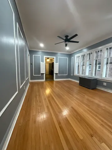 a view of empty room with wooden floor
