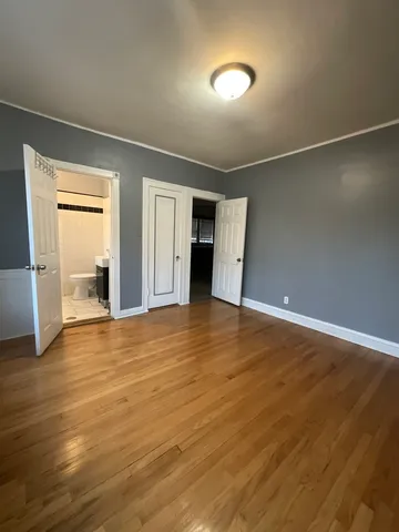 an empty room with wooden floor and closet