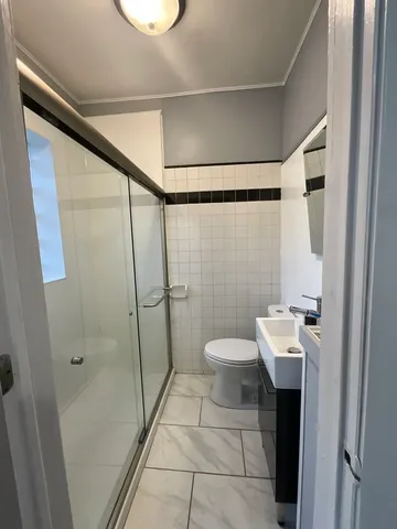 a bathroom with a toilet a sink and shower