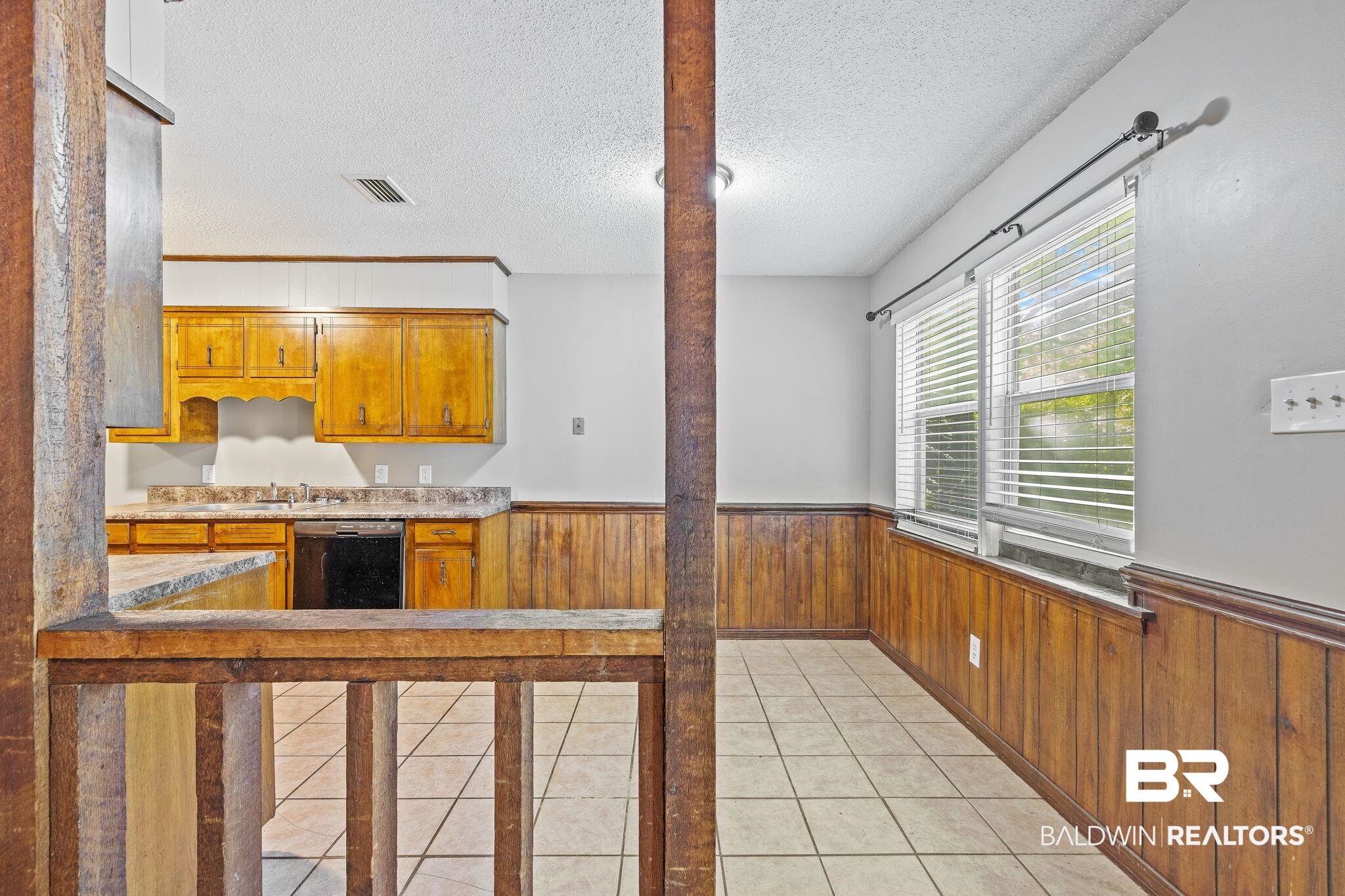 4151 Springdale Road Mobile, AL 36609 - Photo 18 of 21 Kitchen featuring a textured ceiling, wood walls, dishwasher, and light tile patterned floors