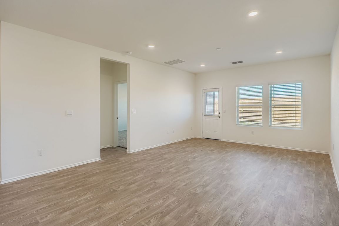12112 Douglas Fir Circle Mustang Ridge, TX 78610 - Photo 12 of 33 a view of an empty room with wooden floor and a window
