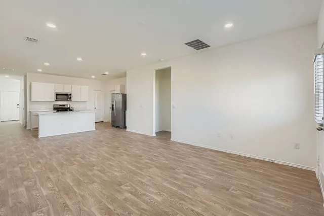a view of a kitchen with a refrigerator and a stove top oven