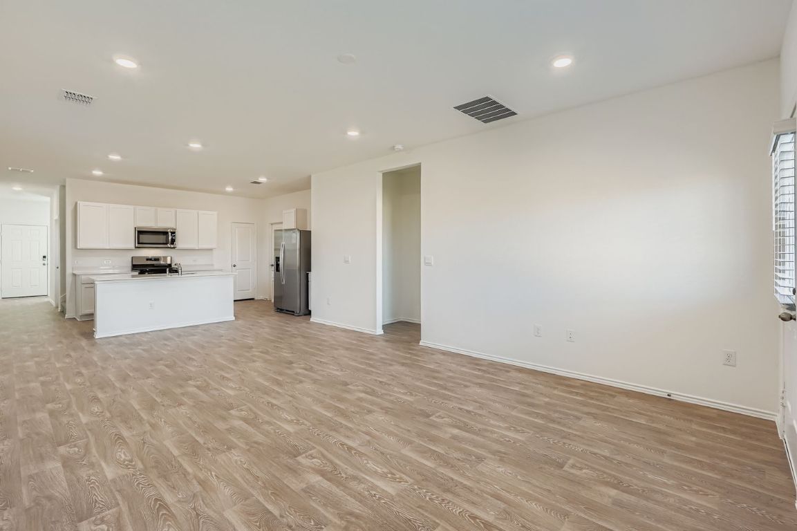 12112 Douglas Fir Circle Mustang Ridge, TX 78610 - Photo 14 of 33 a view of a kitchen with a refrigerator and a stove top oven