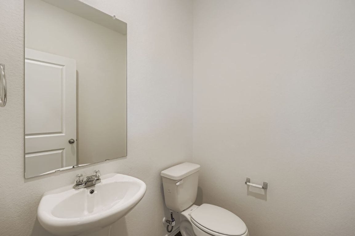 12112 Douglas Fir Circle Mustang Ridge, TX 78610 - Photo 16 of 33 a white toilet sitting next to a white sink