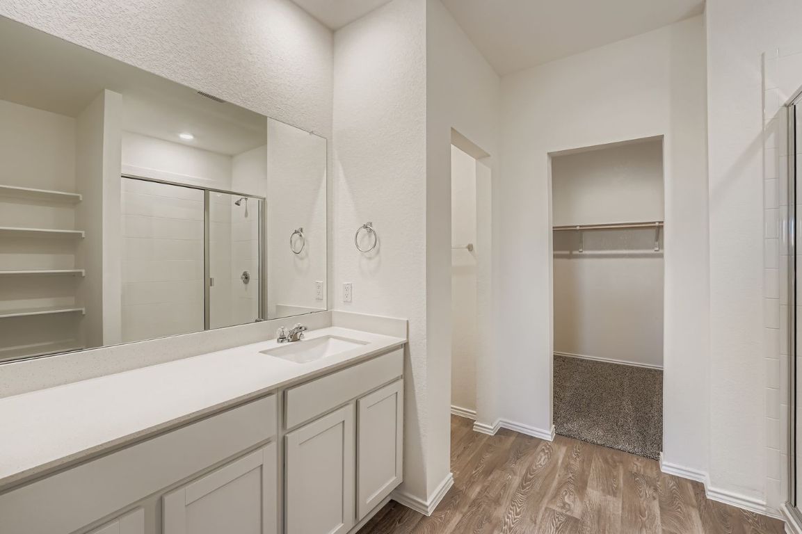 12112 Douglas Fir Circle Mustang Ridge, TX 78610 - Photo 20 of 33 a bathroom with a shower sink and mirror