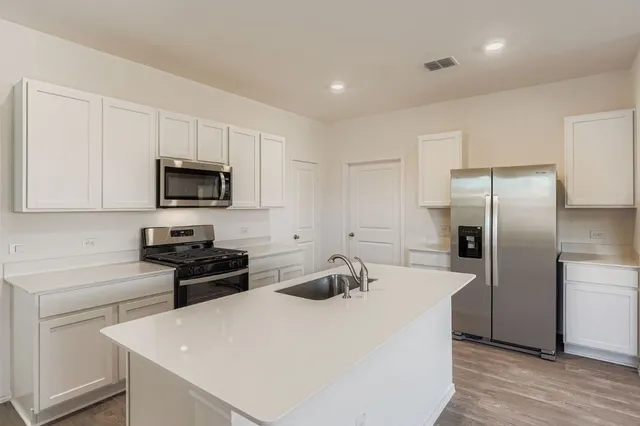 a kitchen with cabinets and stainless steel appliances