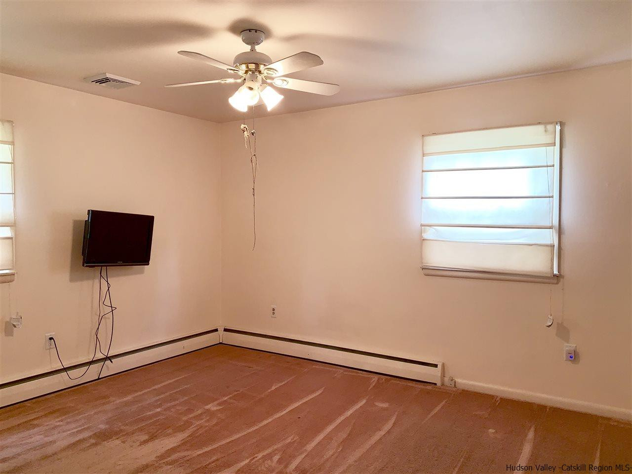222 Rickey Road Stone Ridge, NY 12484 - Photo 8 of 16 a view of an empty room with a window and a ceiling fan