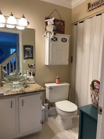 a bathroom with a granite countertop toilet sink and mirror