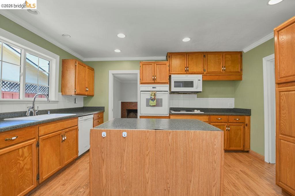 805 Calero Street Milpitas, CA 95035 - Photo 6 of 23 Central kitchen island with wood-finish paneling and dark countertop