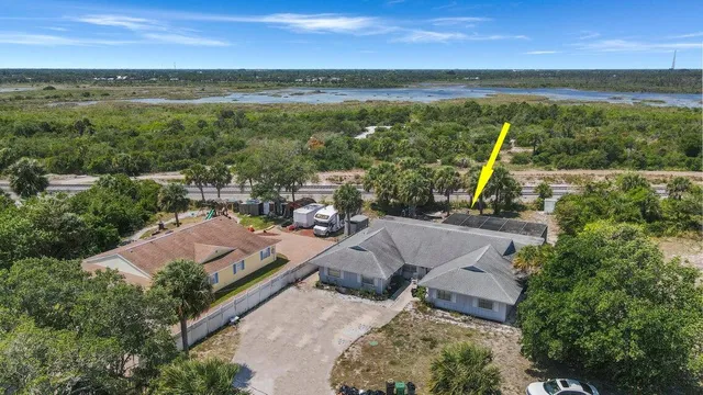 an aerial view of residential houses with outdoor space and ocean view