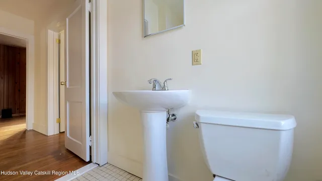 a bathroom with a sink mirror and toilet
