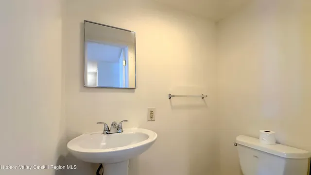 a bathroom with a sink a toilet and mirror