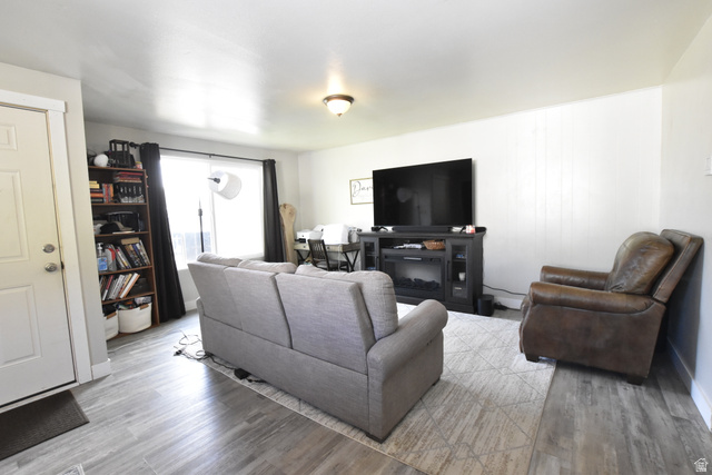 290 West 600 North Logan, UT 84321 - Photo 14 of 45 Bright living area featuring wood-finish flooring, white walls, and a recessed window with dark curtains