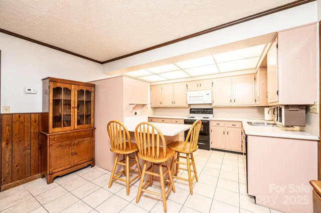 a dining room with stainless steel appliances furniture a large window and a refrigerator