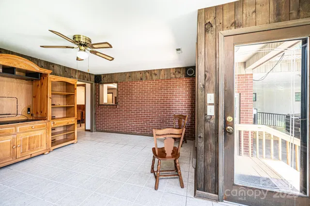 a view of an empty room with a fireplace and a window