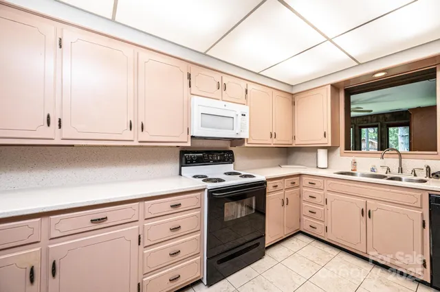 a kitchen with cabinets appliances a sink and a window